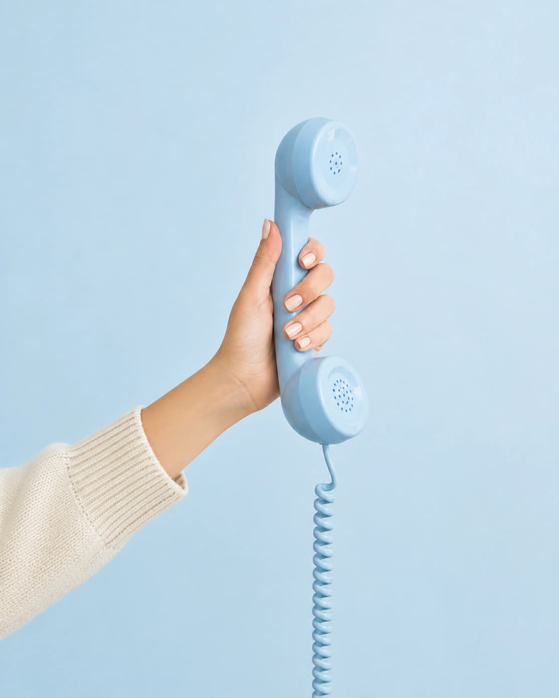 A hand holding a blue telephone receiver